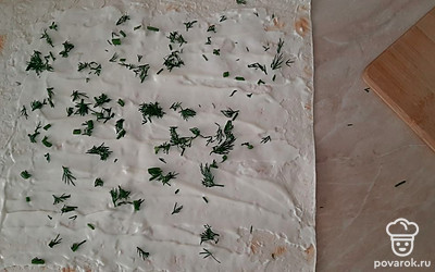 Пока готовиться омлет, мелко нарезаем укроп. На лаваш намазываем сыр и посыпаем укропом. 