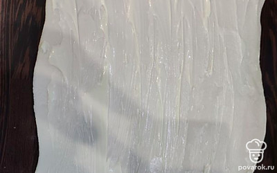 Пласт слоёного теста раскатываем, смазываем тонким слоем майонеза.