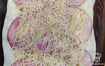 На шинку тонким слоем посыпаем сыр, натертый на мелкой терке.