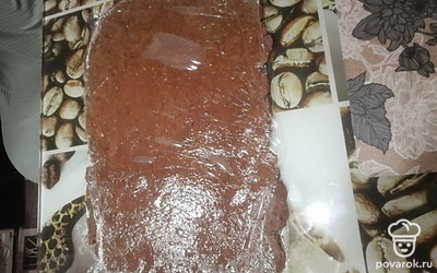 Тесто из печенья выложить на пищевую плёнку или пакет, накрыть сверху плёнкой и раскатать скалкой в пласт толщиной 0,5 см. 