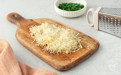 Натрите на мелкой терке пармезан. Измельчите петрушку.