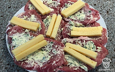 На каждую часть мяса с соусом положите по два бруска сыра, затем сверните каждый кусочек в рулет, закрепите зубочистками или нитью.