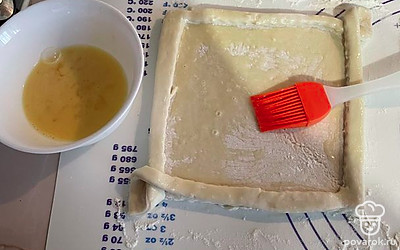 Разбиваем яйцо в миску, перемешиваем и смазываем смесью тесто.
