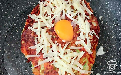 В конце приготовления посыпьте дополнительно сыром и вылейте в центр желток. Накройте крышкой и выключите огонь. 