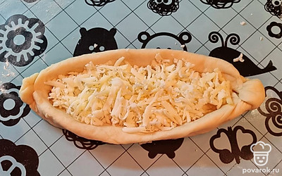 В каждую лодочку положите натертый сыр.