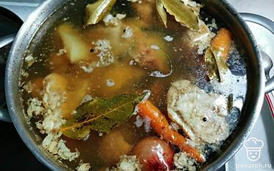 Положить в бульон лук в шелухе и морковь целую. Еще через 2 часа положить лавровый лист и черный перец горошком. Варить еще 1 час.