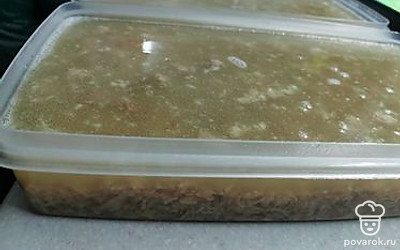 Добавляем тертый чеснок. Распределяем по формам и заливаем процеженным бульоном. Убрать на ночь в холодильник или на холодный балкон (зимой самое то).