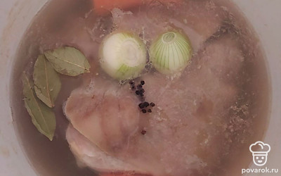 За два часа до готовности добавьте в бульон целый лук, кусочки моркови, лавровый лист и специи по вкусу. После готовности бульона, выньте из него все составляющие.