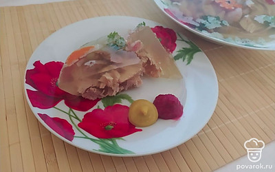 Достаньте холодец из холодильника и немного холодца выложите на тарелку. Рядом с холодцом выложите немного горчицы и хрена со свеклой. Украсьте блюдо свежей зеленью и подавайте к столу как небольшую сытную закуску.