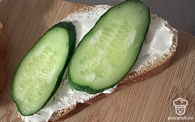 Режем огурцы самыми красивыми ломтиками и укладываем аккуратно на хлеб.