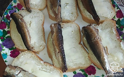 Выложить шпроты и нарезанный ломтиками огурец.