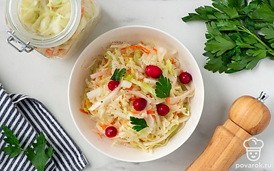 Украсьте квашеную капусту петрушкой и клюквой. Подайте на стол к основному блюду.