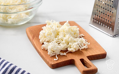 Крупно натрите плавленые сырки в миску с желтками.