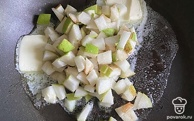 На разогретую сковороду выкладываем сливочное масло и кусочки груши. Тушим на среднем огне минуты 3.