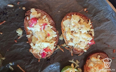 Выложить на хлеб, посыпать сверху тертым сыром. Поставить в духовку на режим «Верх-низ» при температуре 180 градусов до готовности.