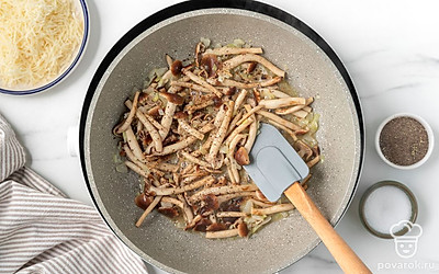 Положите к обжаренному луку опята. Пожарьте все вместе, периодически перемешивая, 3-4 минуты. Посыпьте грибы 1/3 ч.л. соли и черным перцем, размешайте.