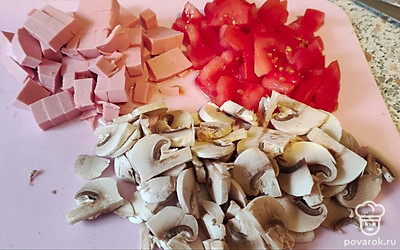 Колбасу, помидорку нарезаем кубиками, шампиньоны нарезаем пластинками. 