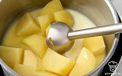 Нагрейте молоко и влейте в кастрюлю с картофелем. Пробейте все блендером до однородной массы без комочков.