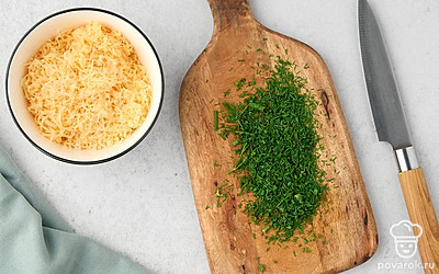 Натрите сыр на мелкой терке. Измельчите зелень.