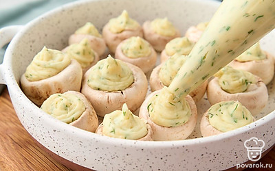 Положите пюре в кулинарный мешок. Начините с его помощью шляпки шампиньонов так, чтобы картофельная масса наполняла их с горкой. Разогрейте духовку до 200 °C. Посыпьте заготовки оставшимся сыром и отправьте запекаться на 15-20 минут в зависимости от мощности духовки. 