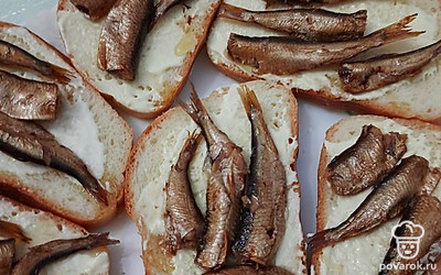 Берем готовый нарезной батон, смазываем каждый кусочек 1 чайной ложкой майонеза и раскладываем шпроты.