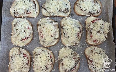 Сыр натереть на тёрке и посыпать бутерброды. 