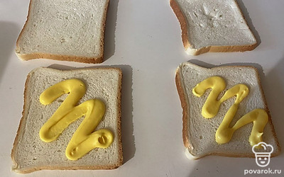 Два ломтика хлеба смажьте сырным соусом. 