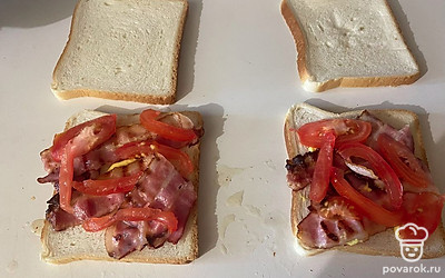 Поверх соуса распределите бекон и кусочки помидора. 