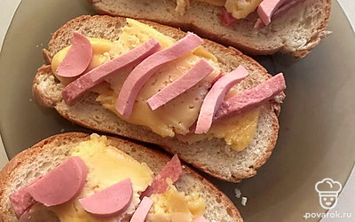 Выкладываем слои на хлеб: сыр, полосочки колбасы, снова сыр и снова полосочки колбасы.