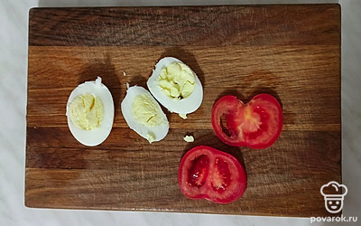 Нарежьте яйца и томаты тонкими ломтиками.