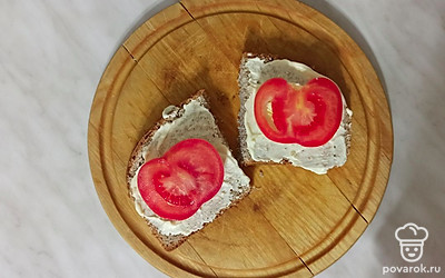 Выложите на батон ломтик яйца, потом ломтик томата.