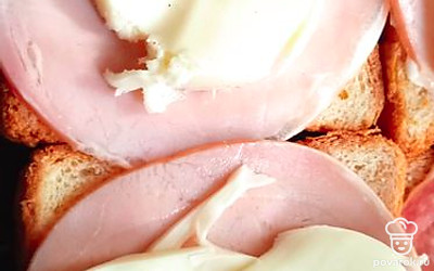 На ветчину положите ломтики сыра. Поставьте в духовку, разогретую до 220 градусов на пять минут. 