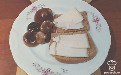 Нарежьте хлеб на ломтики. Положите сверху кусочки сала.