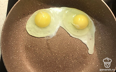 Аккуратно разбейте 2 яйца на сковородку.