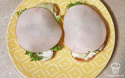 На салат положите кусочки ветчины.