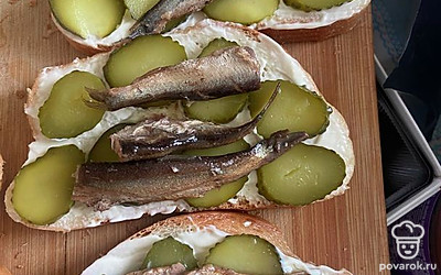 Разложить шпроты поверх огурца.