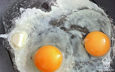 Растопите сливочное масло и разбейте два яица в сковородку. Томите под закрытой крышкой, до готовности.