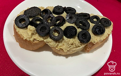 Выкладываем маслины поверх хумуса.