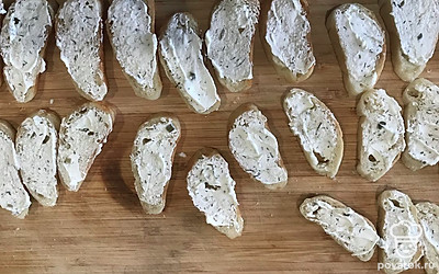 Багет нарежьте на кусочки толщиной 1 или 1,5 сантиметра. Сверху смажьте творожным сыром, можно купить сразу с зеленью, а можно добавить мелко нарезанный укроп.