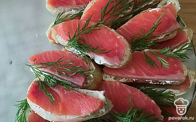 Выкладывайте кусочки рыбы, сверху украшайте листиками укропа.