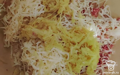 Картошку очистить, помыть, натереть на мелкой терке, отжать и добавить к колбасе с сыром.