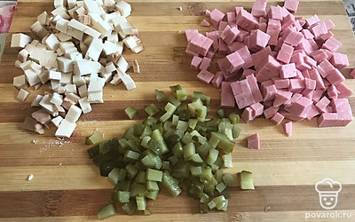 Нарезать кубиками колбасу, огурцы и колбасный сыр.