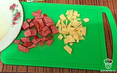 Колбасу и сыр порежьте на кубики.