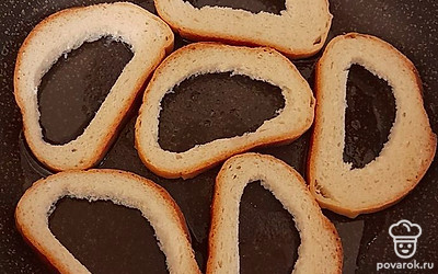 На разогретую сковородку налейте растительное масло и выложите кусочки подготовленного хлеба.