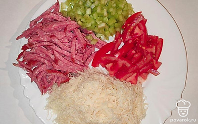 Колбасу нарежьте тонкой соломкой. Помидоры нарежьте на небольшие кусочки. Болгарский перец покрошите мелким кубиком. Сыр натрите на мелкой терке.