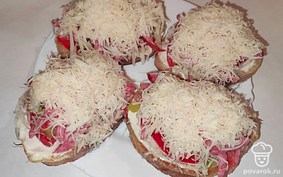 Натертым сыром посыпьте бутерброды. Отправьте на 1 минуту в микроволновку для расплавления сыра.