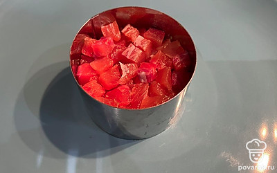 Нарежьте форель кубиками, поперчите, добавьте оливкового масла и уложите в сервировочное кольцо поверх авокадо.