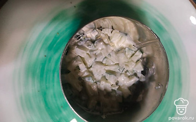 Огурец смешайте с майонезом и выложите в салатное кольцо первым слоем.