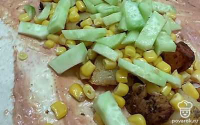 Выложить кукурузу и нарезать огурец. Закрутить начинку лаваш и подогреть.