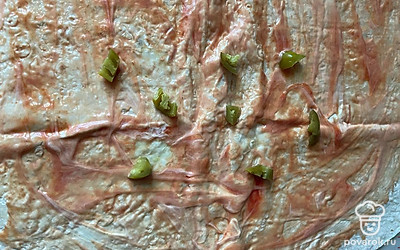 Нарезаем перчик халапеньо и выкладываем его на одну сторону лаваша.